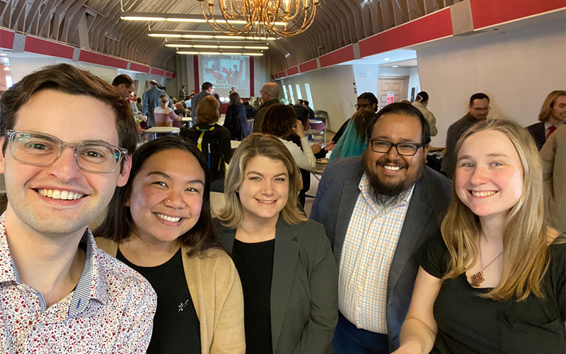 Oscar Martinez smiles with fellow OAE staff as they celebrate him being awarded.