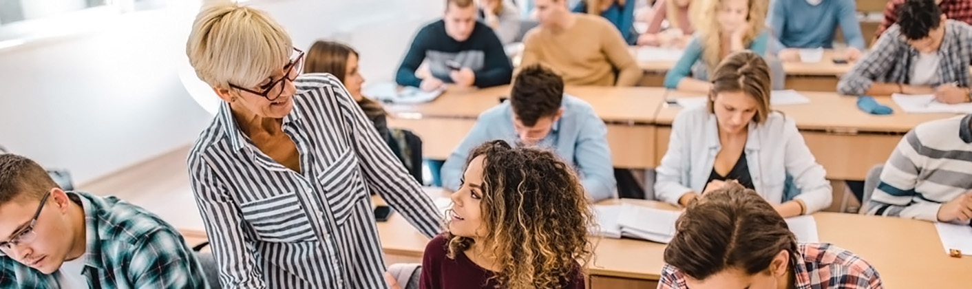 Professor speaking with a student during a hands-on assignment at a lecture.