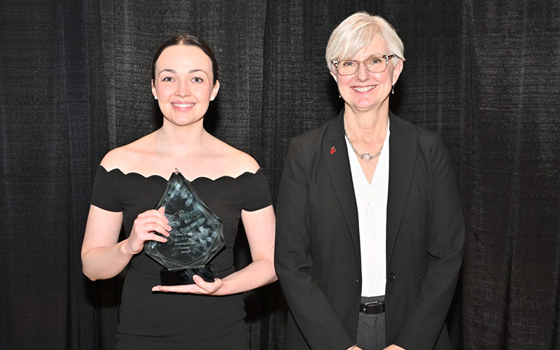 Warren Boyd holds up her award next to Chancellor Chilton.