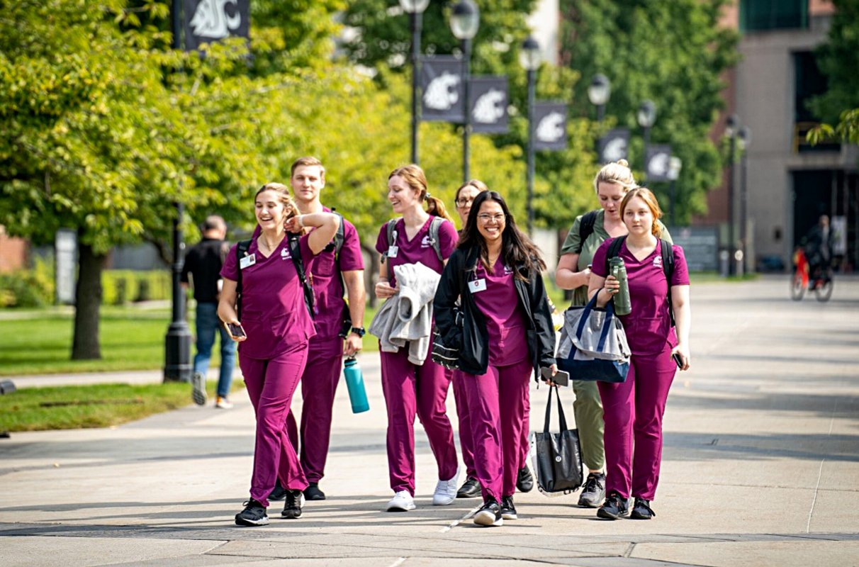 A group of Nursing students walks down the sidewalk on the WSU Spokane campus.