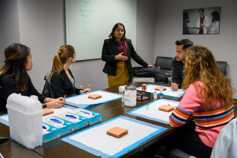 Radha Nandagopal, a new member of the President's Teaching Academy, speaks to students around a table.