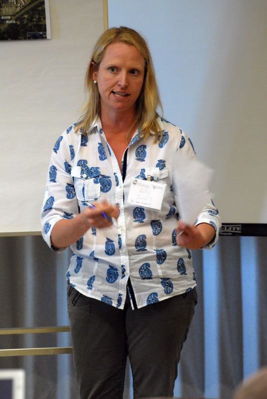 a woman gesturing with her paper as she gives a presentation