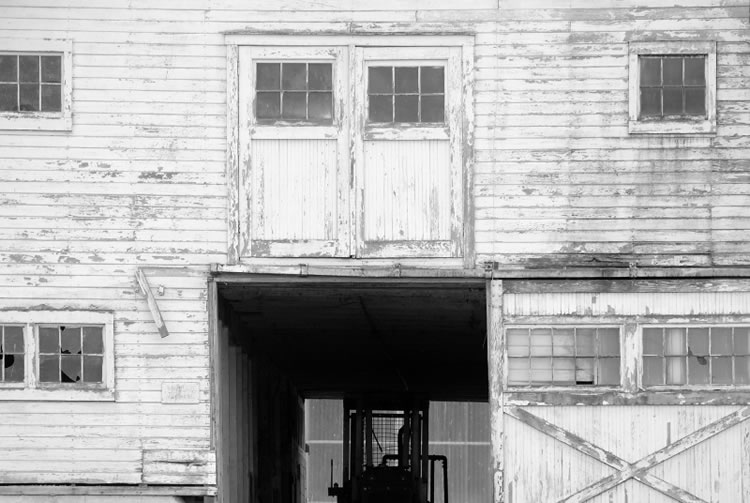 b&w photo of a forklift in a building with flaking white paint