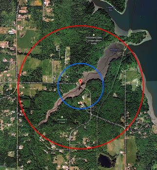 the same land area as is shown in the map above. the site is noted by a red mark. A blue circle is centered around it, and a larger red circle is around the outside of that.
