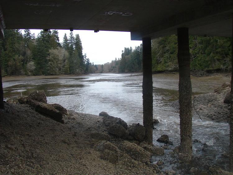 Looking downstream at a river from under a bridge