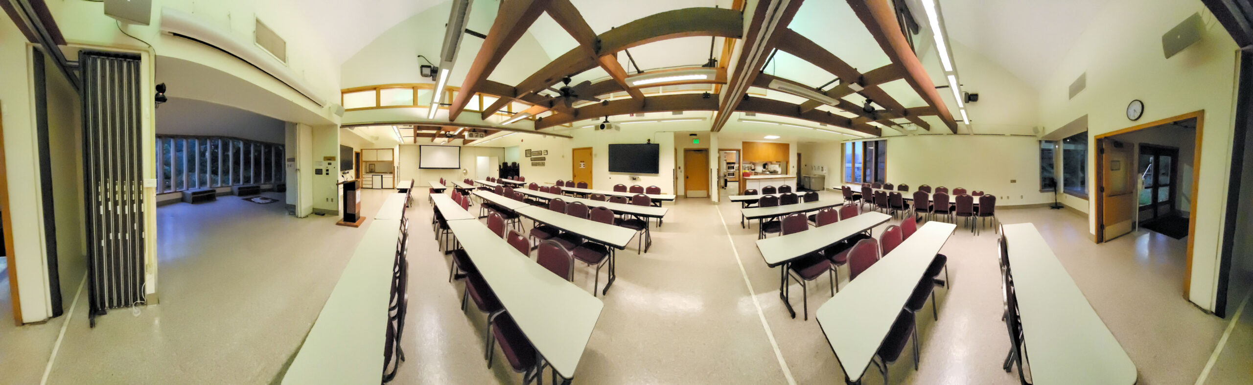 Forced 360-degree panorama of a large open meeting room from an aisle between tables.