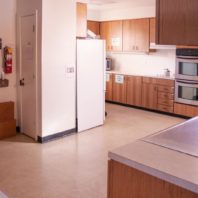 Large kitchen space with refrigerator, microwave, stove, and double wall ovens.