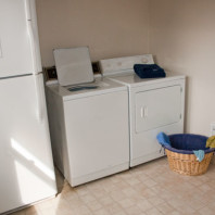 Lundry room with refrigerator, washin machine and clothes dryer.