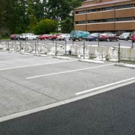 Permeable concrete parking lot with permeable asphalt lot in background.