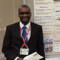 Man in suit stands next to a research poster.