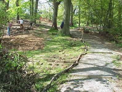 Using woody debris to edge a gravel path and keep mulch off the path.