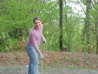 Woman raking in mulch bed.