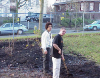 Two students pause with shovel while digging.