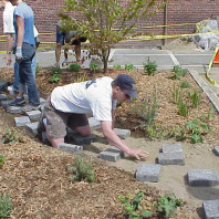 Installing pavers to create a path through the big bed.