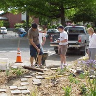 Installing pavers to create a path through the big bed.