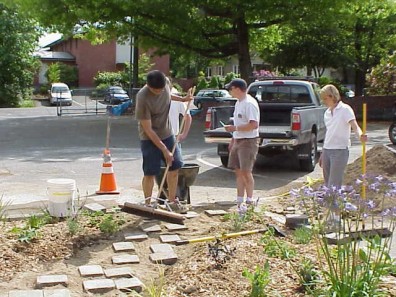 Installing pavers to create a path through the big bed.
