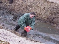 Hand seeding to stabilize the slope.