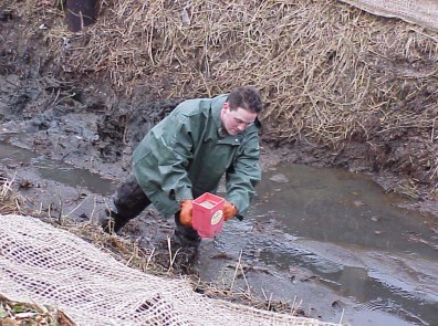 Hand seeding to stabilize the slope.
