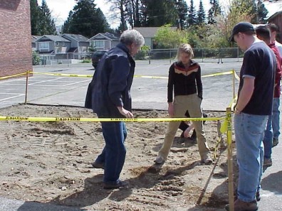 Examining the soil following asphalt removal.