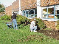 Removing weeds and turf from the planting bed near the school.