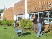 Removing weeds and turf from the planting bed near the school.