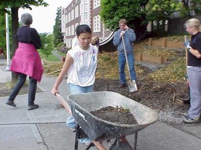 Garfield students move soil and mulch near the newly installed terrace.