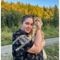 a woman holding a cat outside
