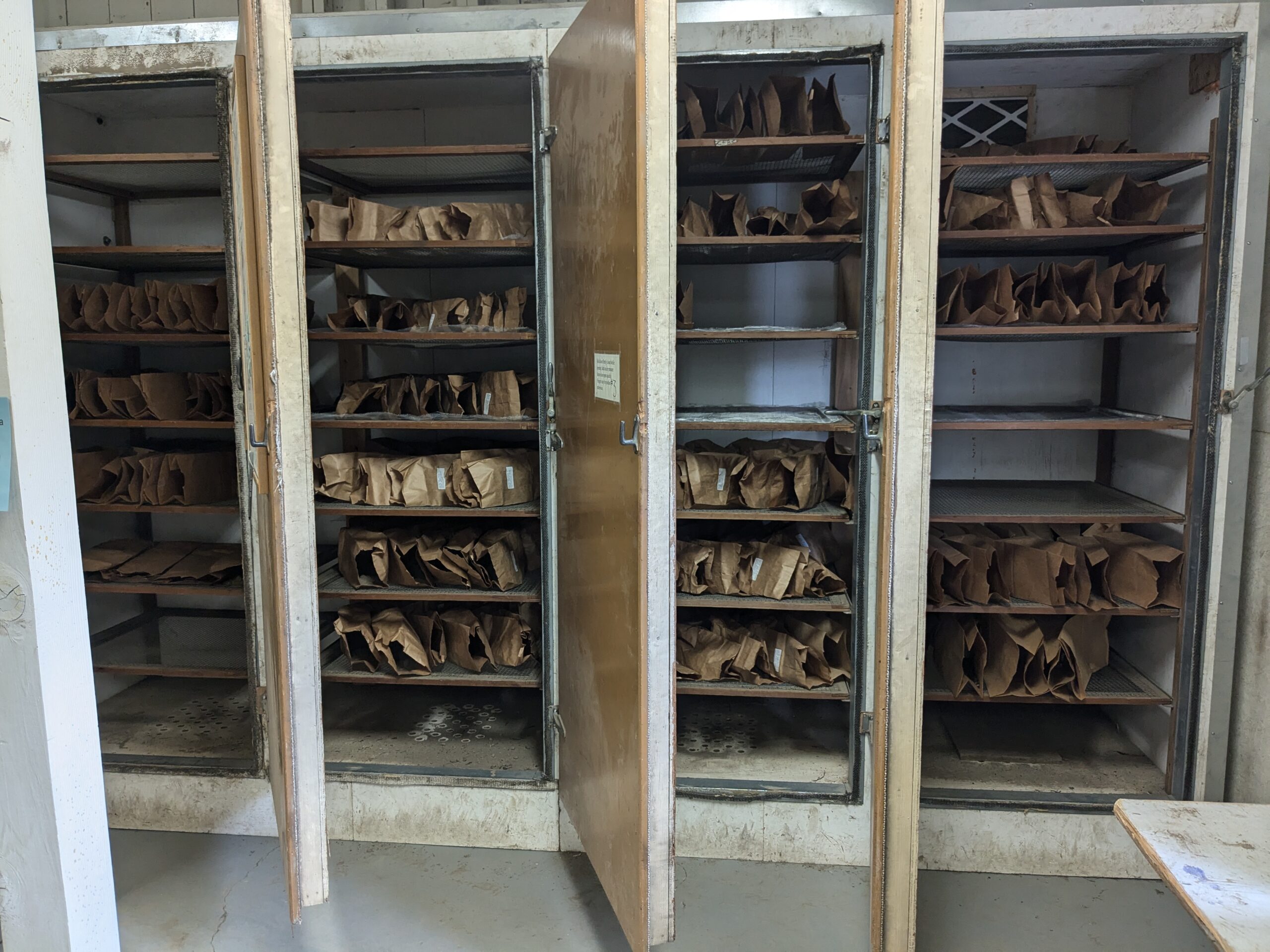 cabinet soil dryer with many bags of soil samples in individual paper bags