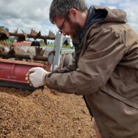 Researcher testing compost moisture by hand.