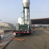 Struvite processing cone raised on trailer in front of dairy buildings.