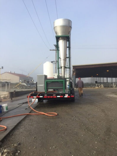 Struvite processing cone raised on trailer in front of dairy buildings.