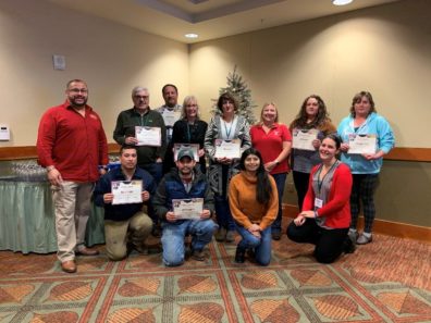 LEADS graduates pose in ballroom with their certificates.