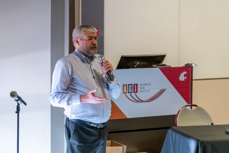 A man holding a microphone and speaking into it