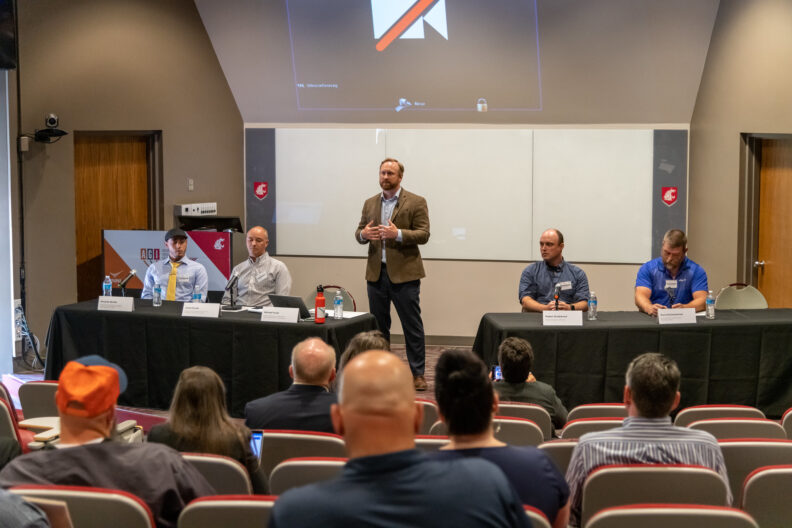 A man standing up on a stage giving a presentation