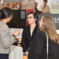 A group photo of three faculty members having a conversation at the Recognition Reception