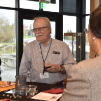 A group photo of three faculty members having a conversation at the Recognition Reception
