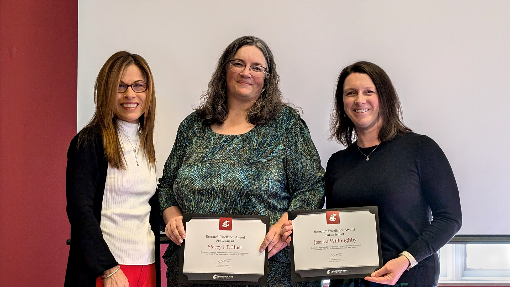 Stacey Hust and Jessica Willoughby holding award certificates and posing with Kim Christen.