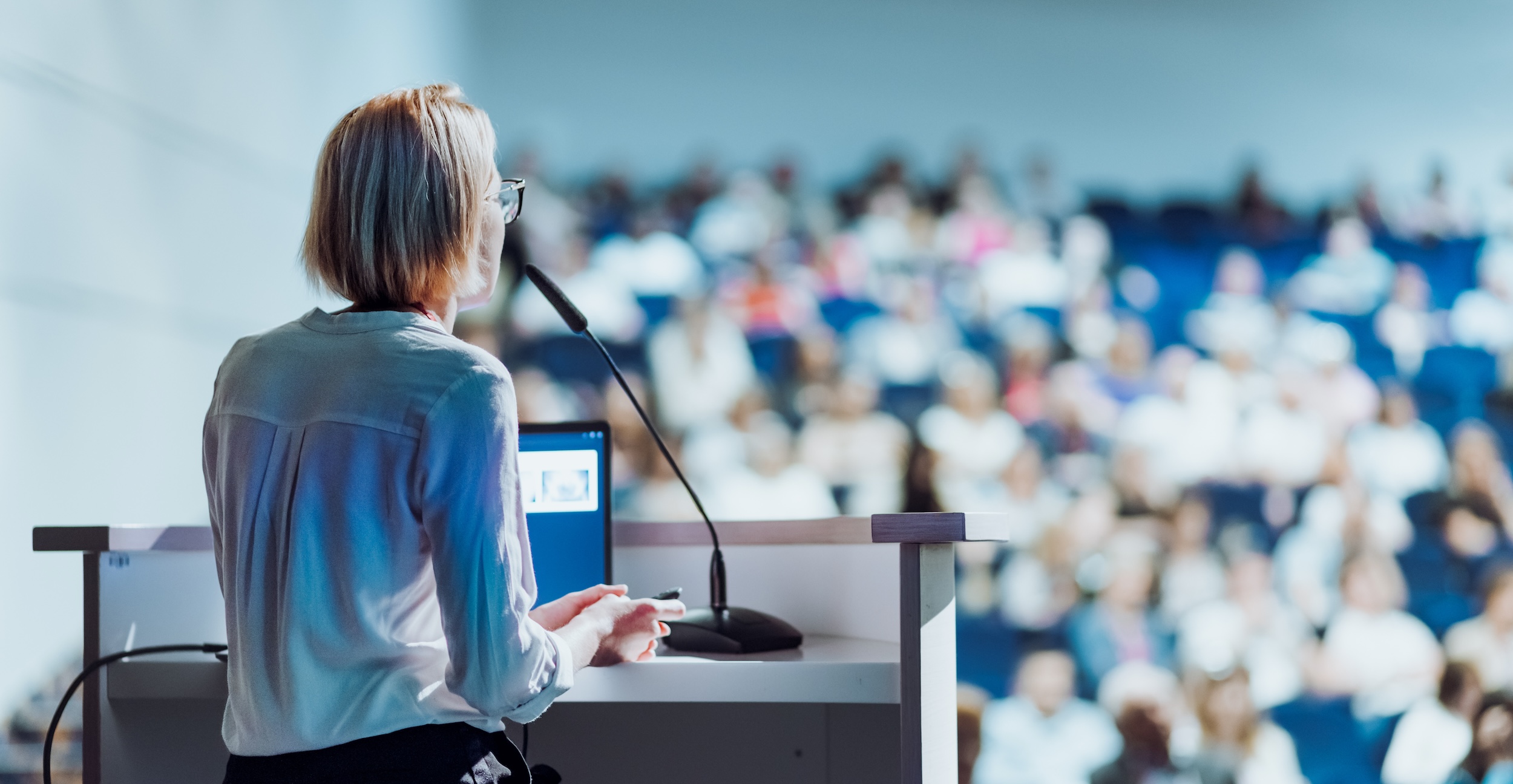A professor speaks to a large class