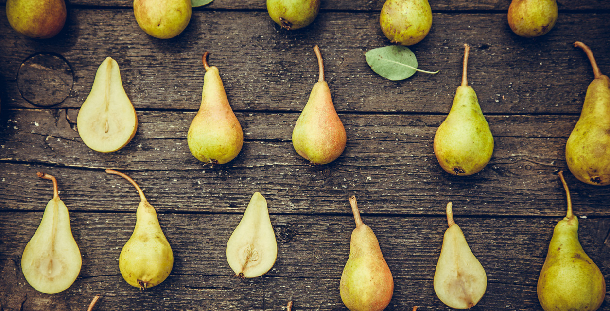 Whole and half pears on table. 