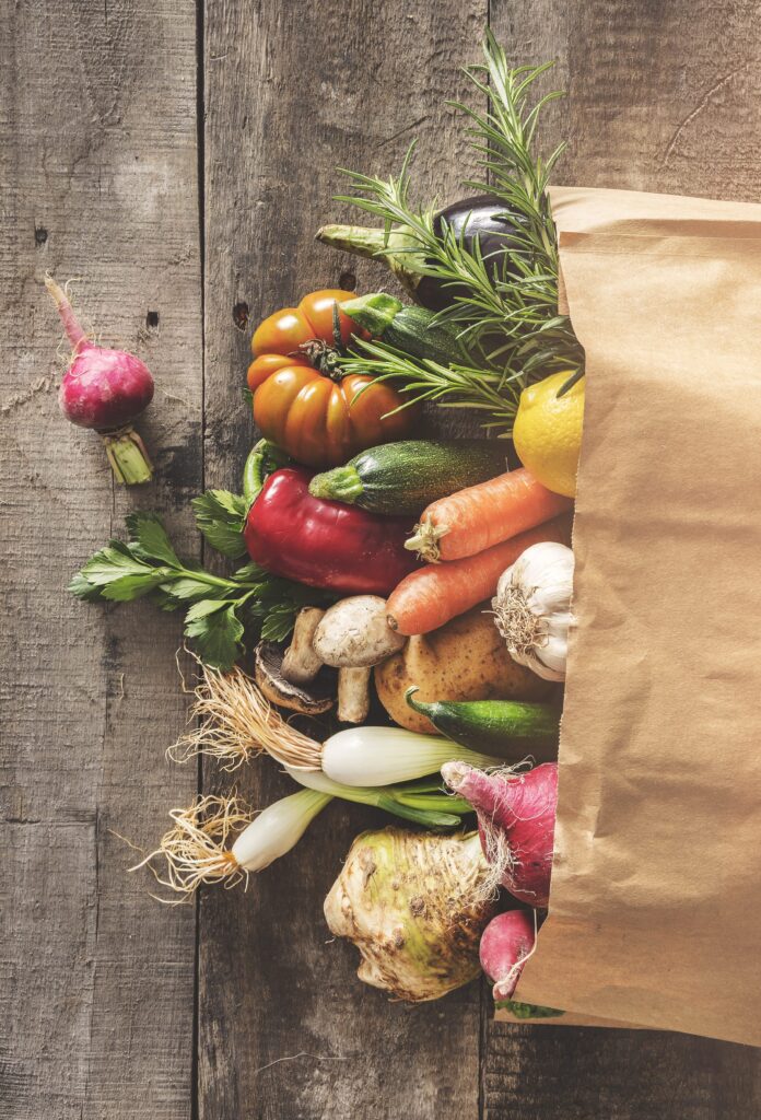 vegetables in grocery bag on brown background