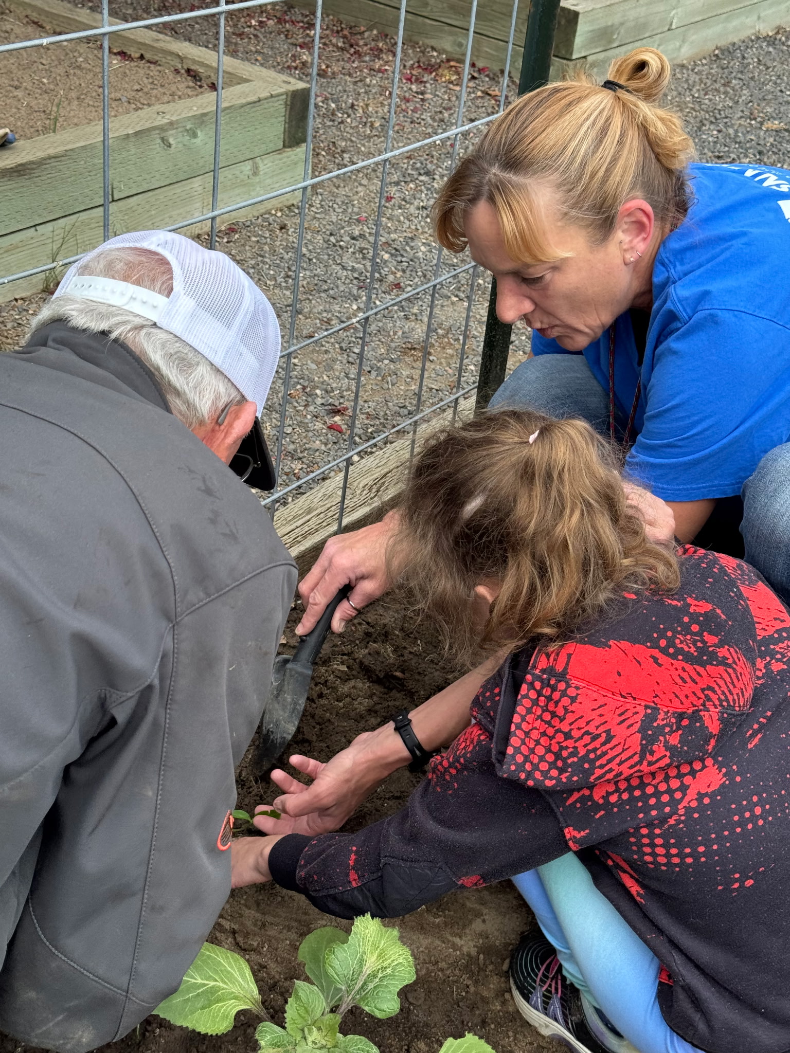 SNAP-Ed educator and students planting in school garden