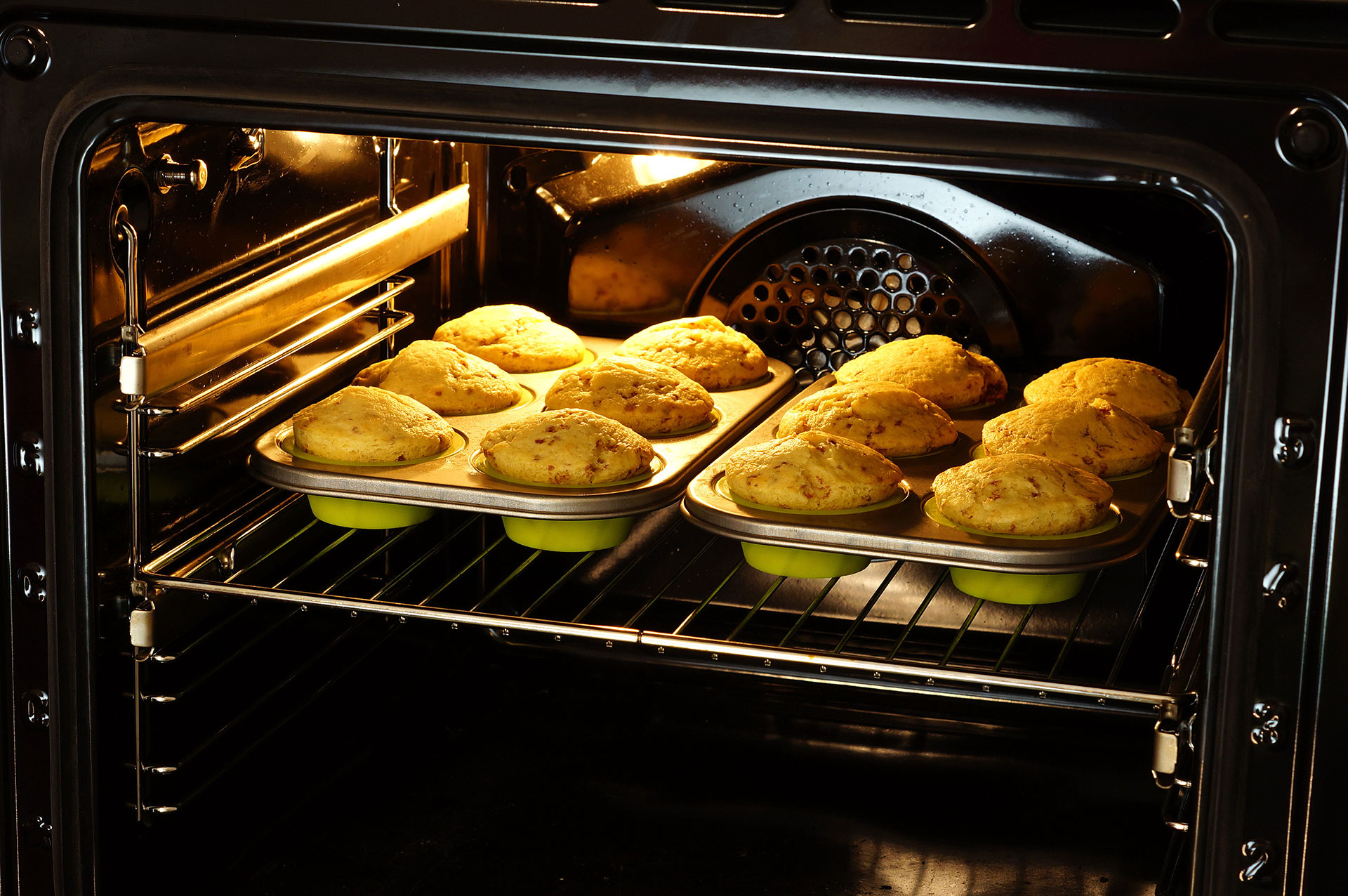 Two trays of muffins in the oven.