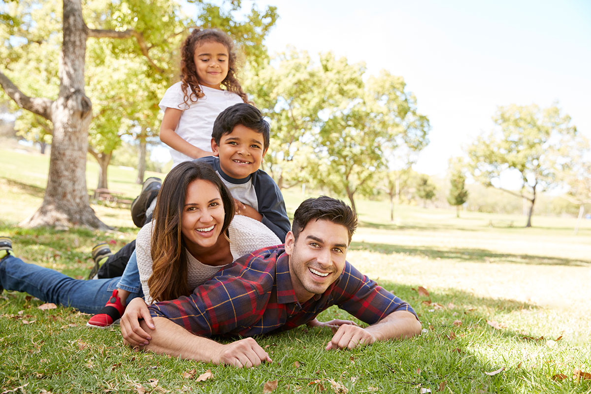 A mother, father, and two children in the park.