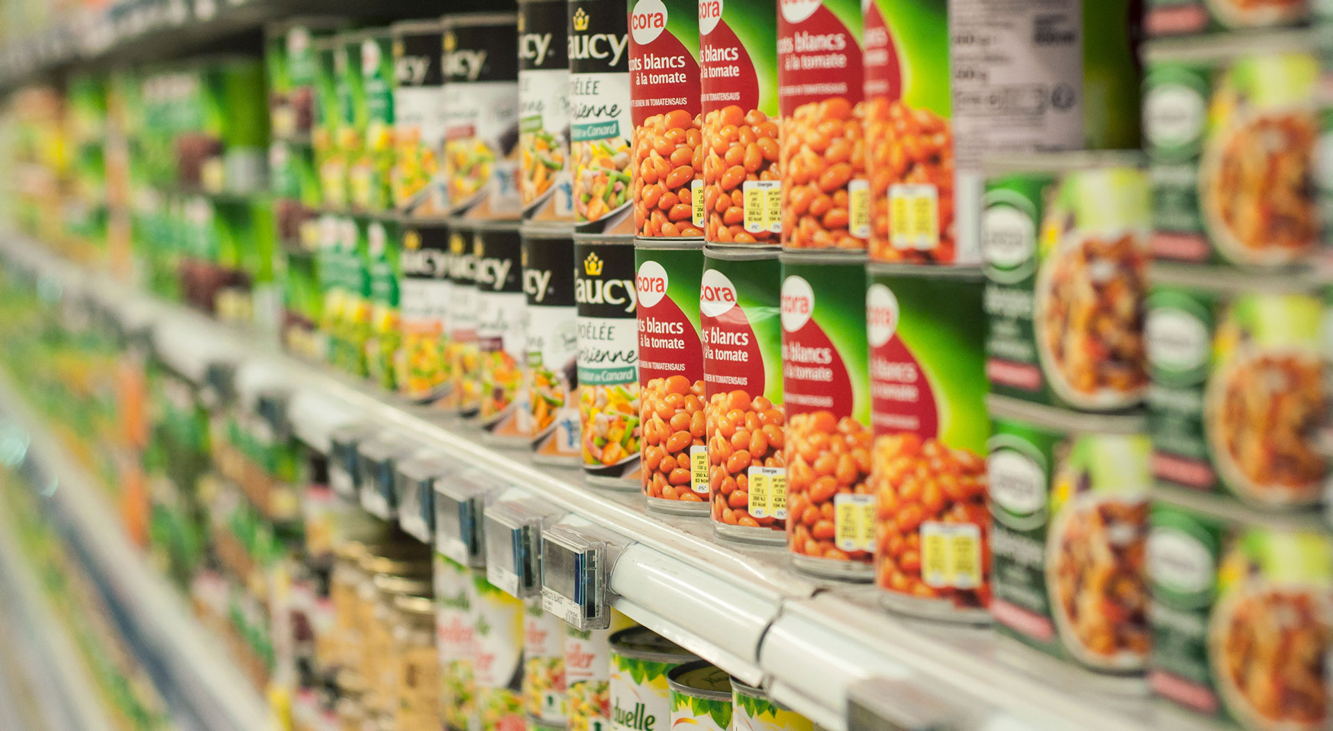Rows of canned goods on a shelf at a store.
