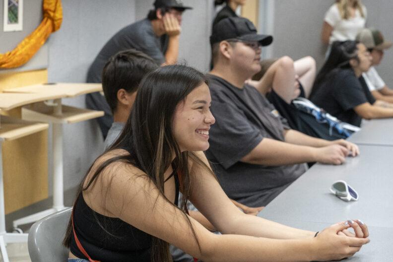 Sports clinic students sitting and smiling while listening to presentation