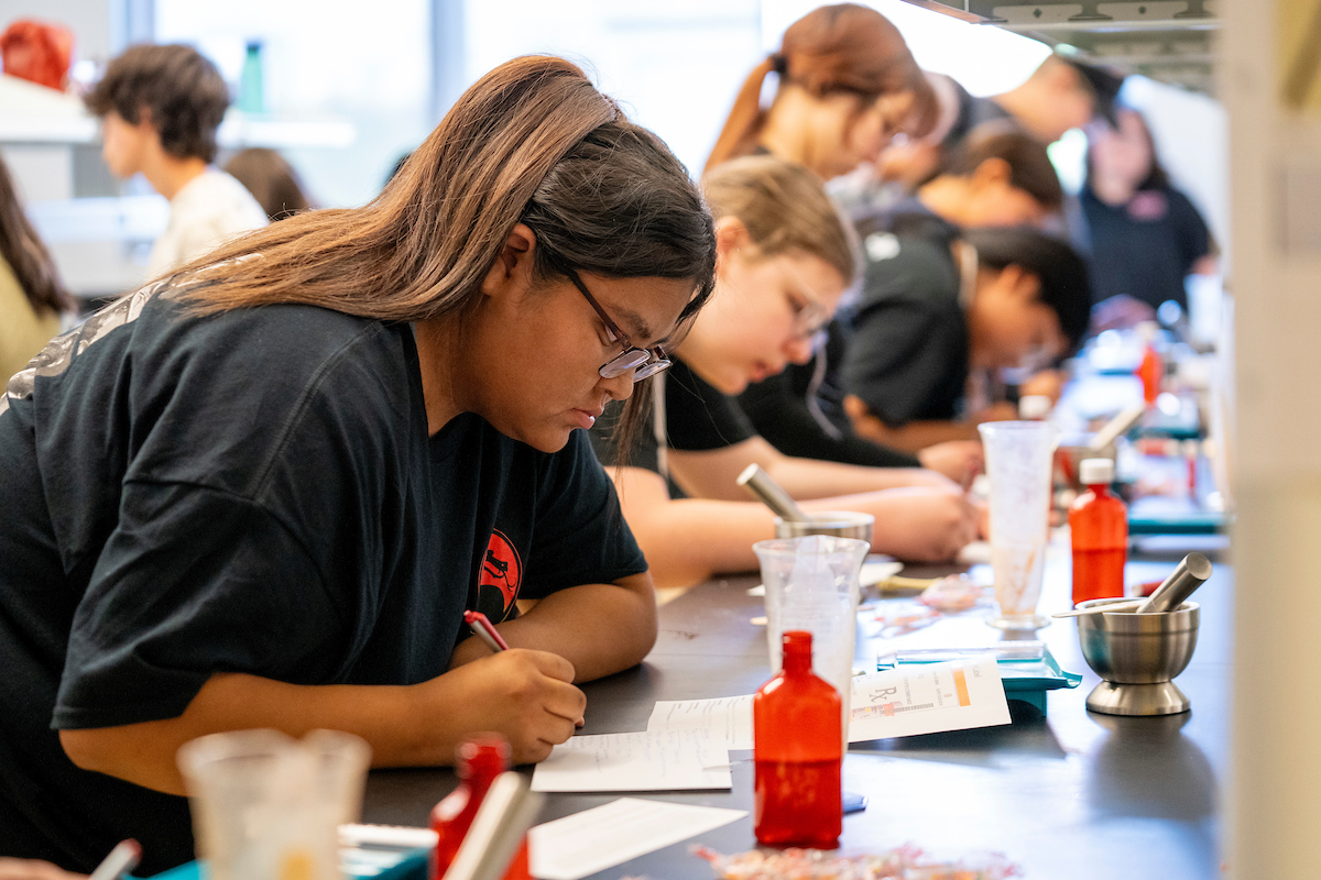 Na-ha-shnee program student sitting at a table together