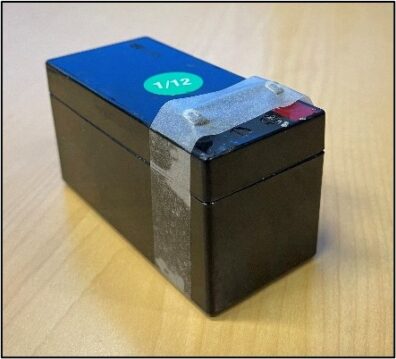 Battery with terminals taped to block contact points for safety