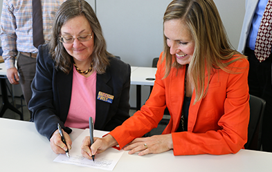 Heritage University Provost Laurie Fathe, left, and WSU College of Pharmacy Assistant Dean for Recruitment and Student Success Jennifer Robinson sign agreements. (Photo by David Mance, Heritage University)