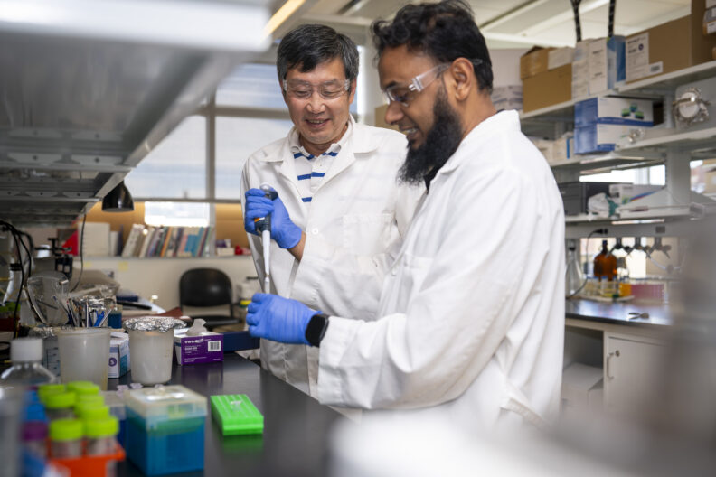Jiyue Zhu (left) in the lab with his student.