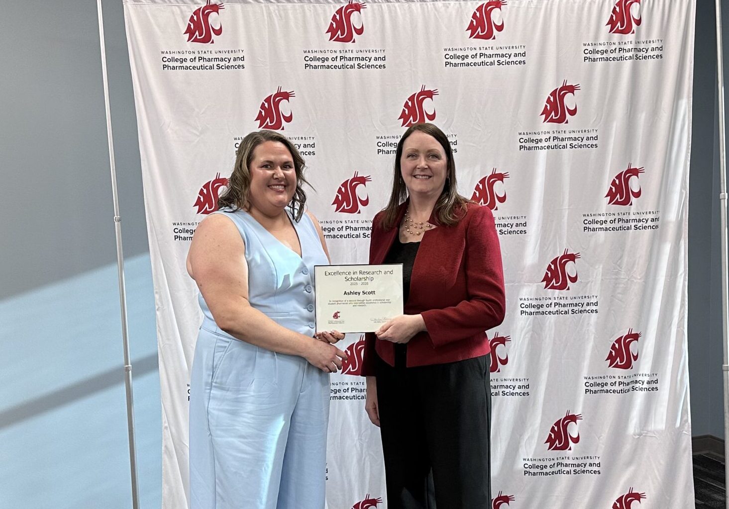 Ashley Scott receiving Excellence in Research and Scholarship award from Interim Dean Julie Akers